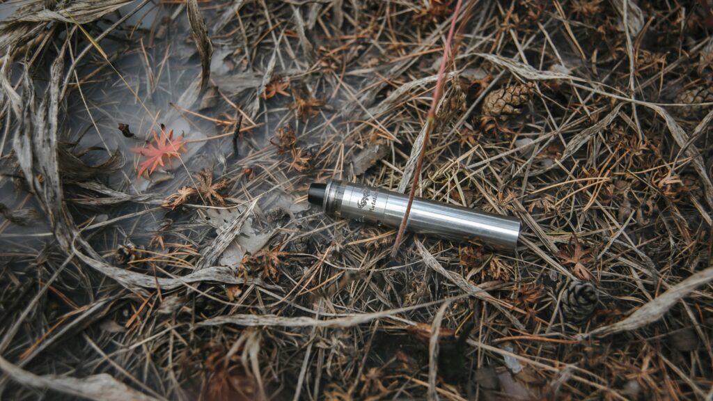 Disposable vape discarded on a pile of leaves