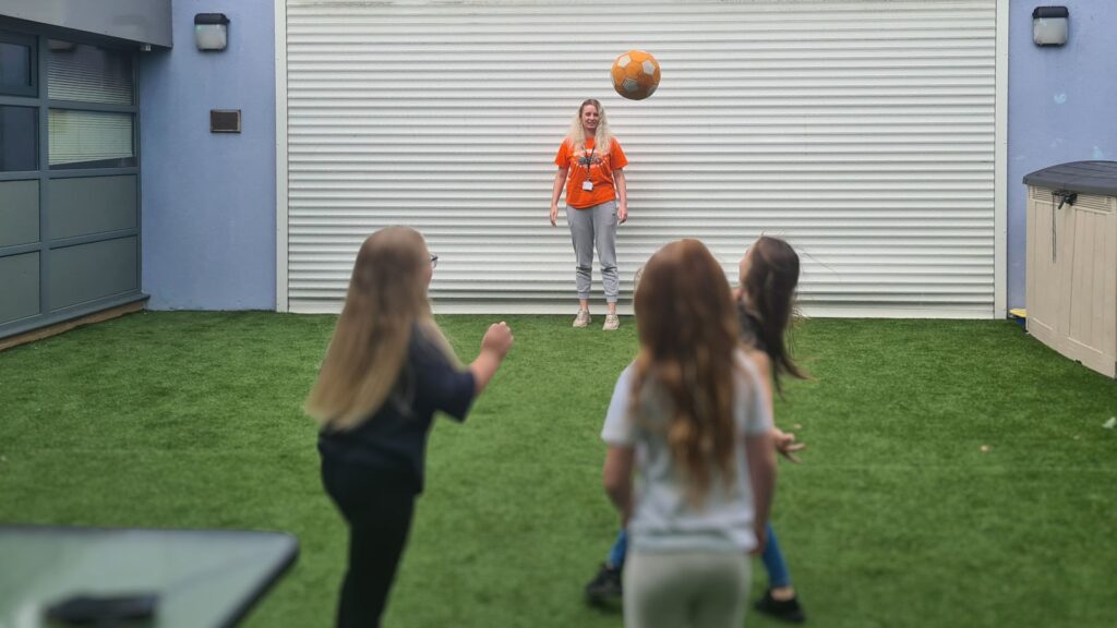 Two children playing ball with Subwize staff.