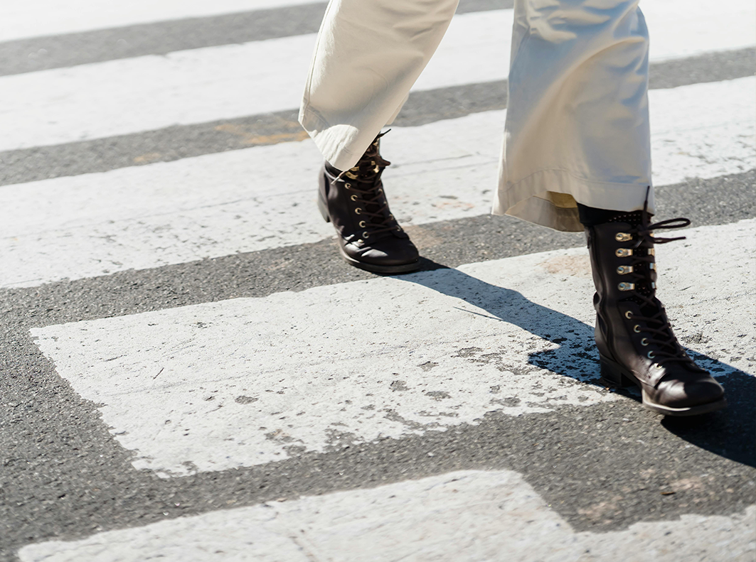 close up of person walking across zebra crossing